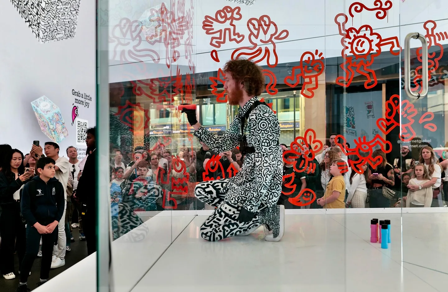 Mr Doodle drawing red doodles inside glass Kleenex tissue box at Outernet London