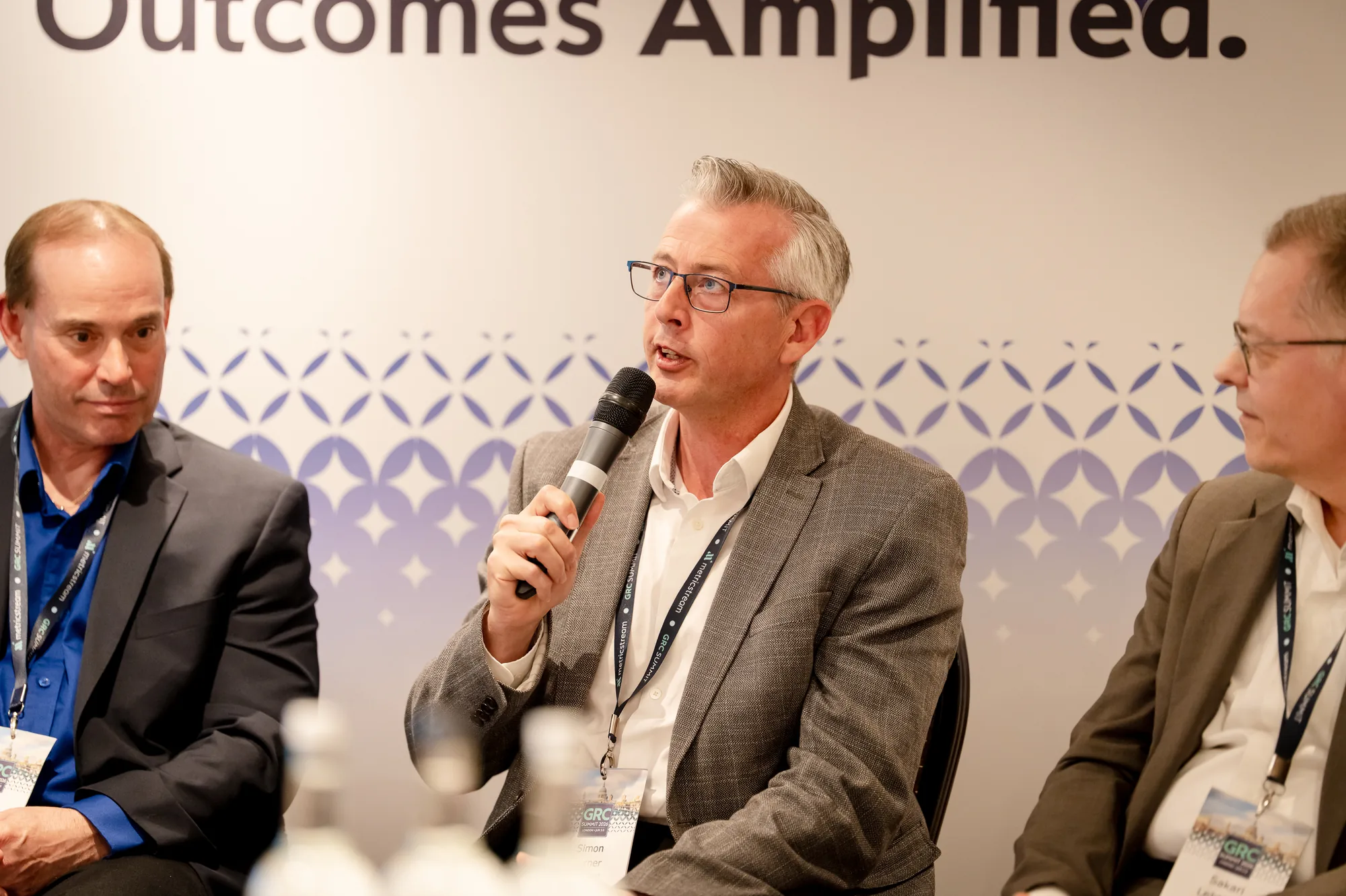 breakout-speaker-microphone-branded-backdrop-grc-summit-2026