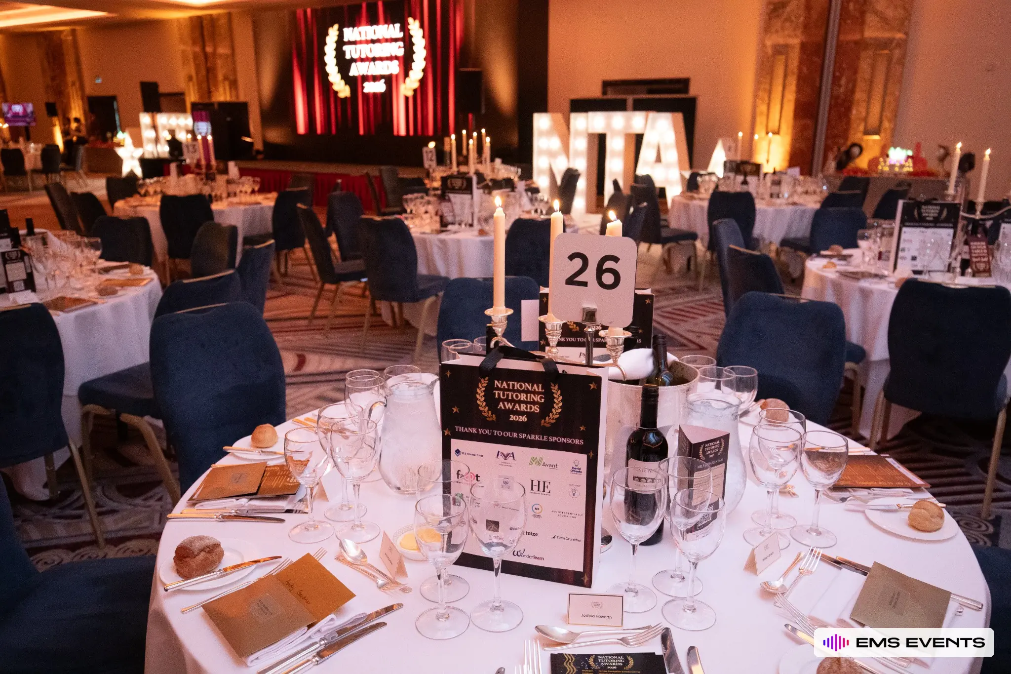 Set banquet table with National Tutoring Awards 2026 sponsor bag and candlelit centrepiece at Royal Lancaster London