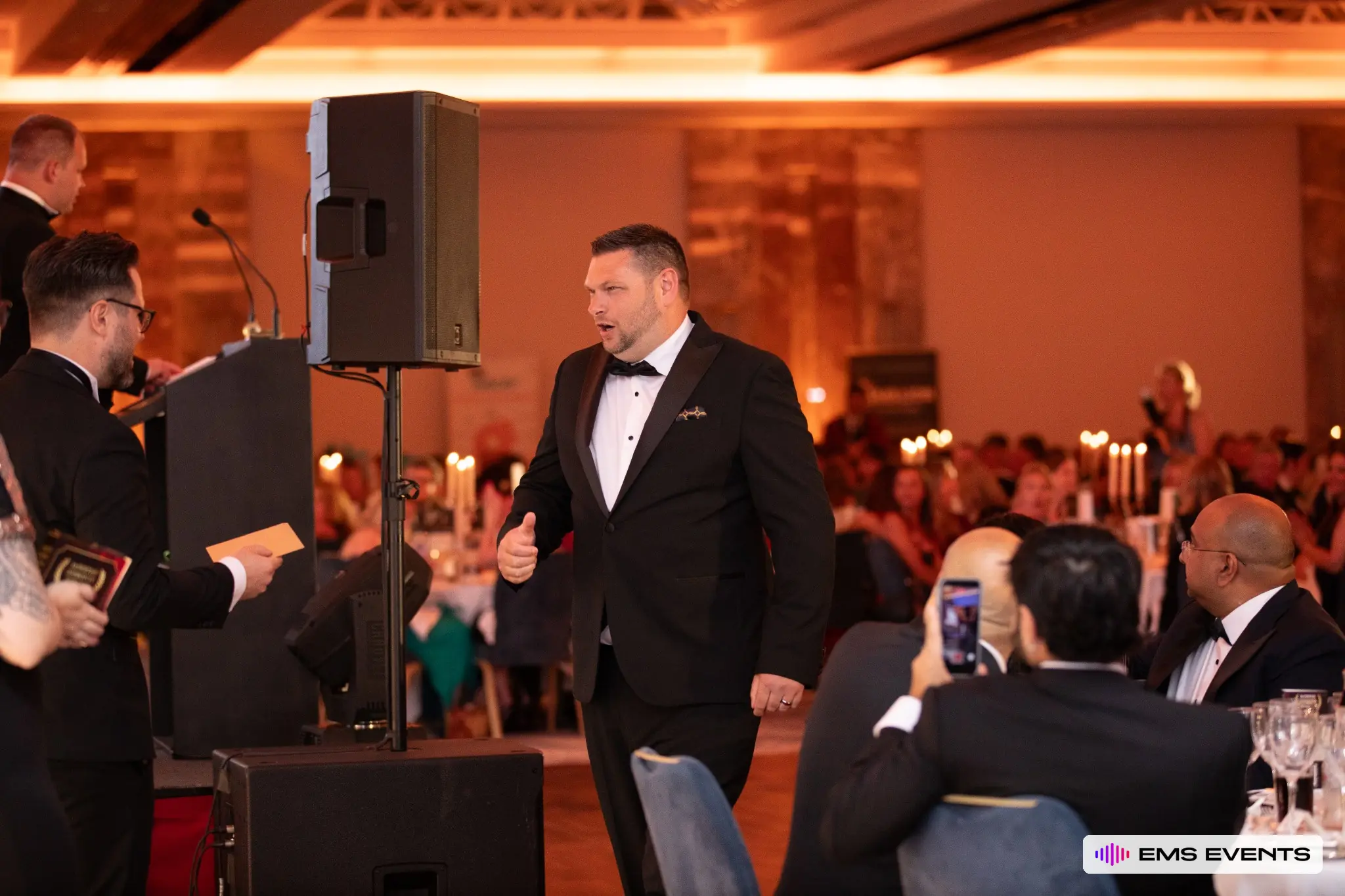 Award winner walking through the audience towards the stage at The Tutors' Association's 5th National Tutoring Awards